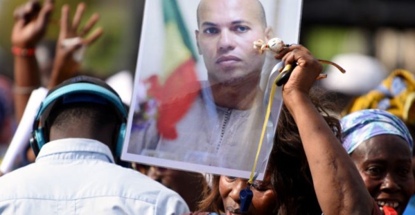 © Seyllou, AFP | Le portrait de Karim Wade, ex-ministre et fils de l'ancien président du Sénégal, brandi lors d'une manifestation de l'opposition à Dakar, en février 2015. © Seyllou, AFP | Le portrait de Karim Wade, ex-ministre et fils de l'ancien président du Sénégal, brandi lors d'une manifestation de l'opposition à Dakar, en février 2015.