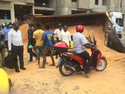 Photos :  La benne d’un camion de sable se renverse sur un taxi. Regardez