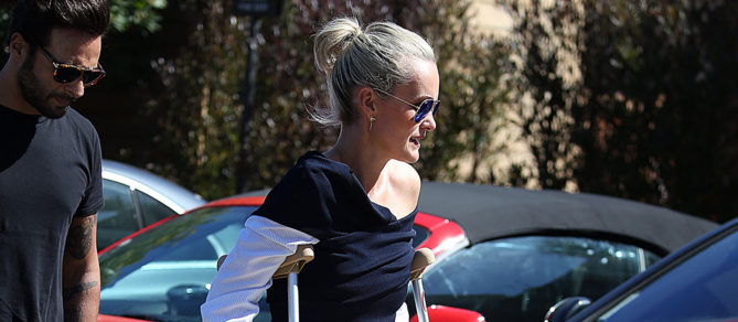 PHOTOS – Laeti­cia Hally­day en fauteuil roulant: son diffi­cile vol vers Paris