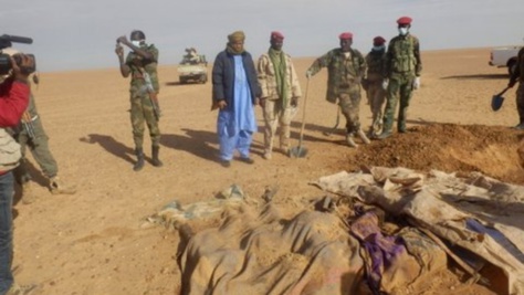 Des soldats nigériens devant les cadavres de migrants abandonnés dans le désert