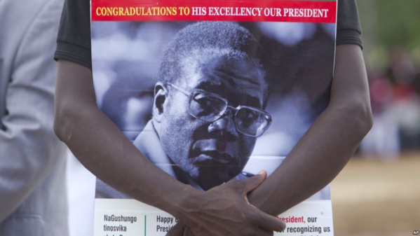 Un partisan du président zimbabwéen Robert Mugabe tient le portrait de celui-ci lors des célébrations du 93e anniversaire de celui-ci à Matopos, dans la banlieue de Bulawayo, 25 février 2017.