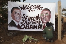 Artist Ouzin puts the finishing touches on a painting honoring the upcoming visit to Dakar by President Obama. Senegalese President Macky Sall is pictured on the right of the painting.