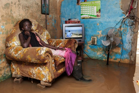 Chaussée de bottes en caoutchouc, Fanta, 18 ans, une habitante de Thiaroye, attend patiemment que l'eau se retire. A la recherche d'un travail, ils sont de plus en plus nombreux à quitter la campagne et à venir s'installer à la périphérie de la capitale.