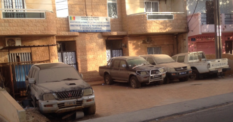 Cimetière de voitures devant un bâtiment officiel - Cela se passe au Sénégal !