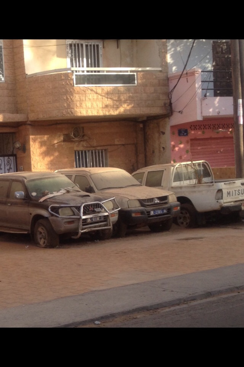 Cimetière de voitures devant un bâtiment officiel - Cela se passe au Sénégal !