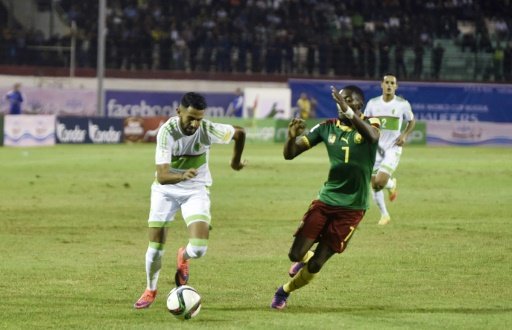 © AFP | La star de l'Algérie Ryad Mahrez à la lutte avec Toko Ekambi du Cameroun en qualifications au Mondial-2018, le 9 octobre 2016.