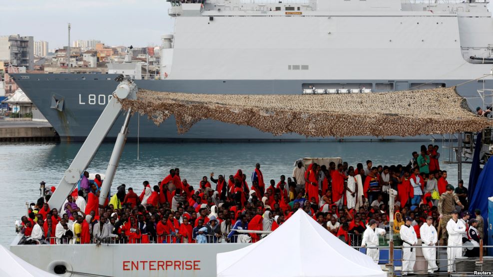 Des migrants attendent pour descendre du bateau de la Royal Navy Ship HMS Enterprise dans un port sicilien, Italie, le 23 octobre 2016.