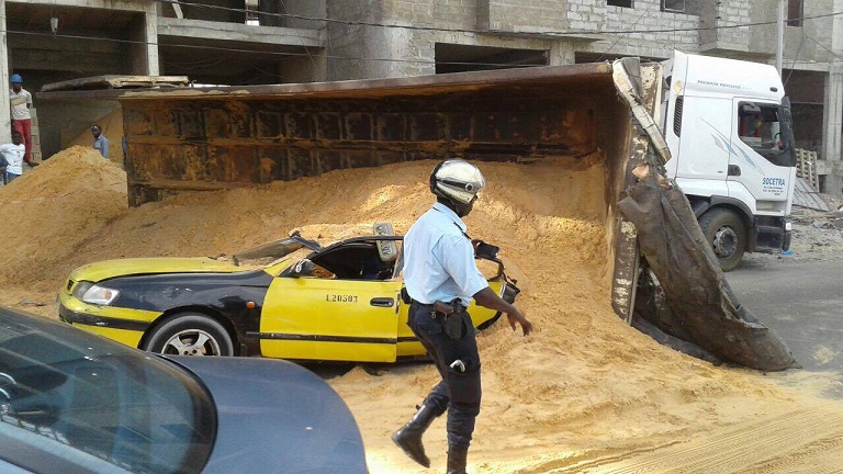 Photos :  La benne d’un camion de sable se renverse sur un taxi. Regardez