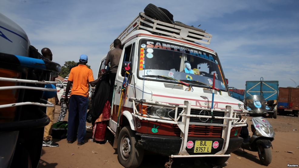 Des passagers montent dans un bus à Serrekunda, dans la capitale gambienne, Banjul, le 17 janvier 2017.
