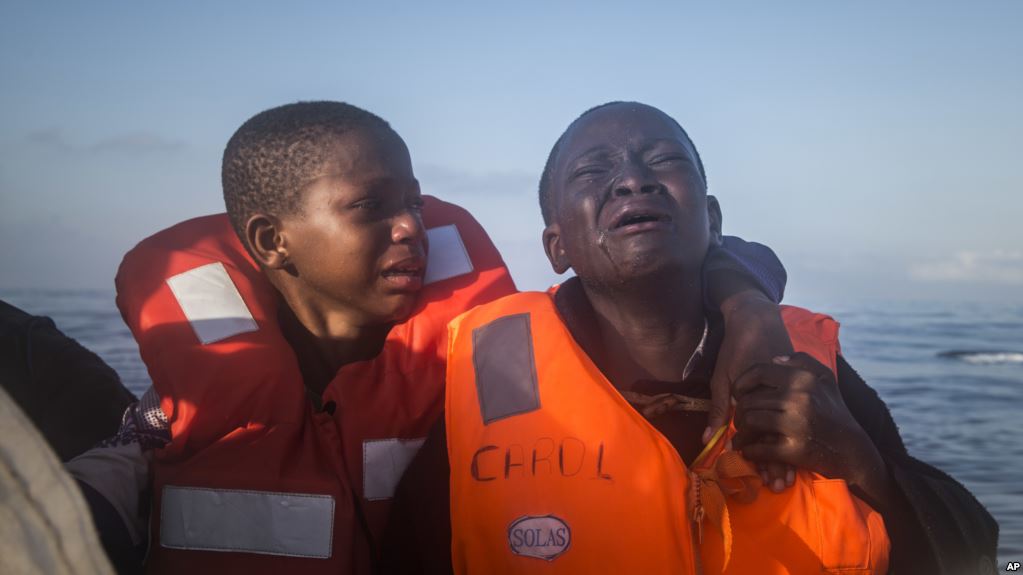 "une fille de 11 ans du Nigeria (à gauche), qui m'a dit que sa mère est morte en Libye, pleure à côté de son frère de 10 ans à bord d'un bateau de sauvetage d'une ONG. Les enfants ont navigué pendant des heures dans un bateau en caoutchouc surchargé avec d'autres réfugiés lors d'une opération de sauvetage sur la Méditerranée, à environ 23 kilomètres au nord de Sabratha, en Libye"