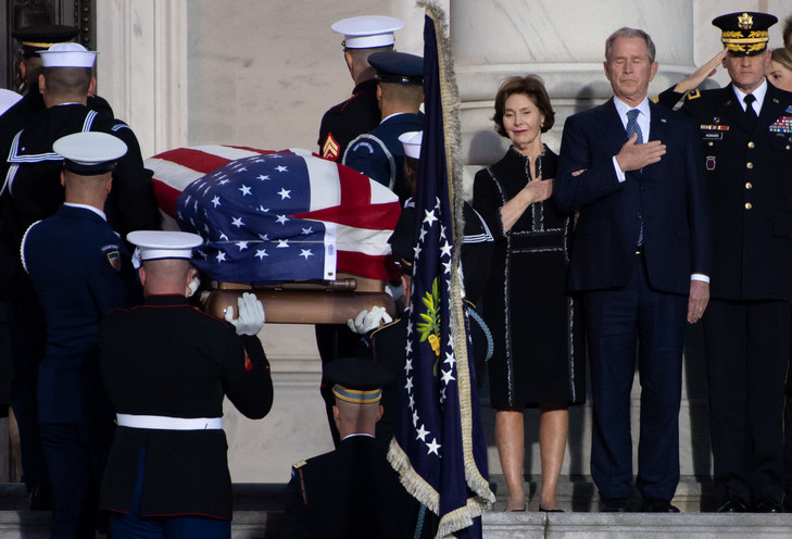 L'ancien président américain George W. Bush et son épouse Laura se recueillent à l'arrivée du cercueil de George H. W. Bush au Capitole, le 3 décembre 2018 / AFP