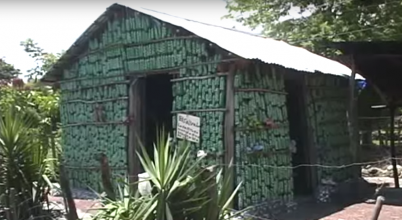 Une femme construit une maison à l'aide de matériaux recyclés