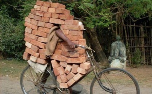 Regardez, il transporte des briques sur son vieux vélo !