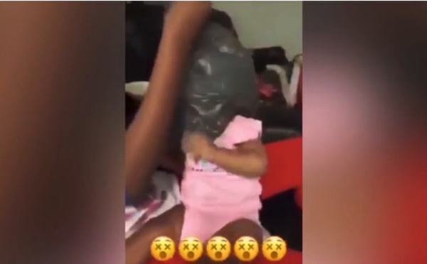 Deux jeunes parents placent un sac de plastique sur la tête de leur bébé puis le plonge dans l'eau pour l'empêcher de respirer