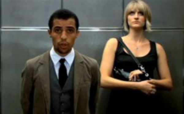 Femme blanche et homme noir dans un ascenseur