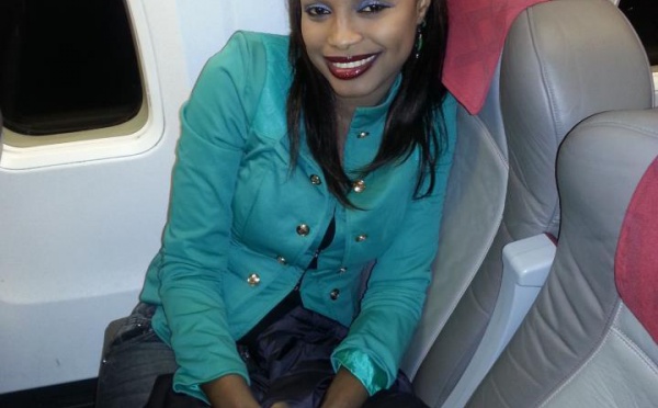 La danseuse Mbathio toute souriante dans son avion