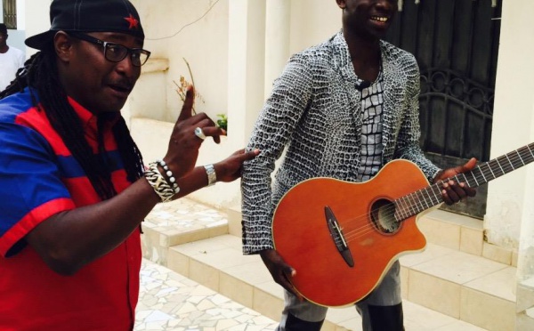 Awadi offre une guitare à Pape Diouf