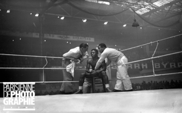 Guerre 1939-1945. Assane Diouf, boxeur français, conseillé par ses soigneurs, lors de son match contre Jean Despeaux. Paris, palais des sports, avril 1941.