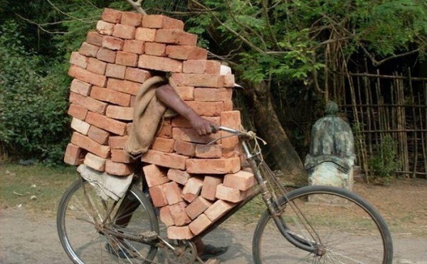 Regardez, il transporte des briques sur son vieux vélo !