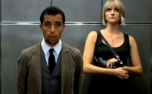 Femme blanche et homme noir dans un ascenseur