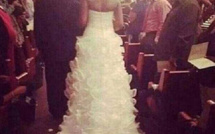 Son bébé d'un mois attaché à sa traîne de robe de mariée