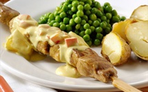 Brochettes de viande, sauce au curry, petits pois et pommes de terre soufflées