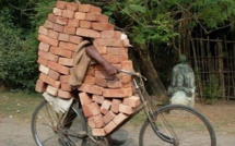 Regardez, il transporte des briques sur son vieux vélo !