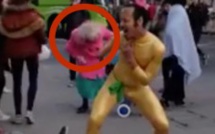 L’homme en costume doré danse au milieu de la rue. Mais regardez ce que fait la mamie avec le manteau rose!